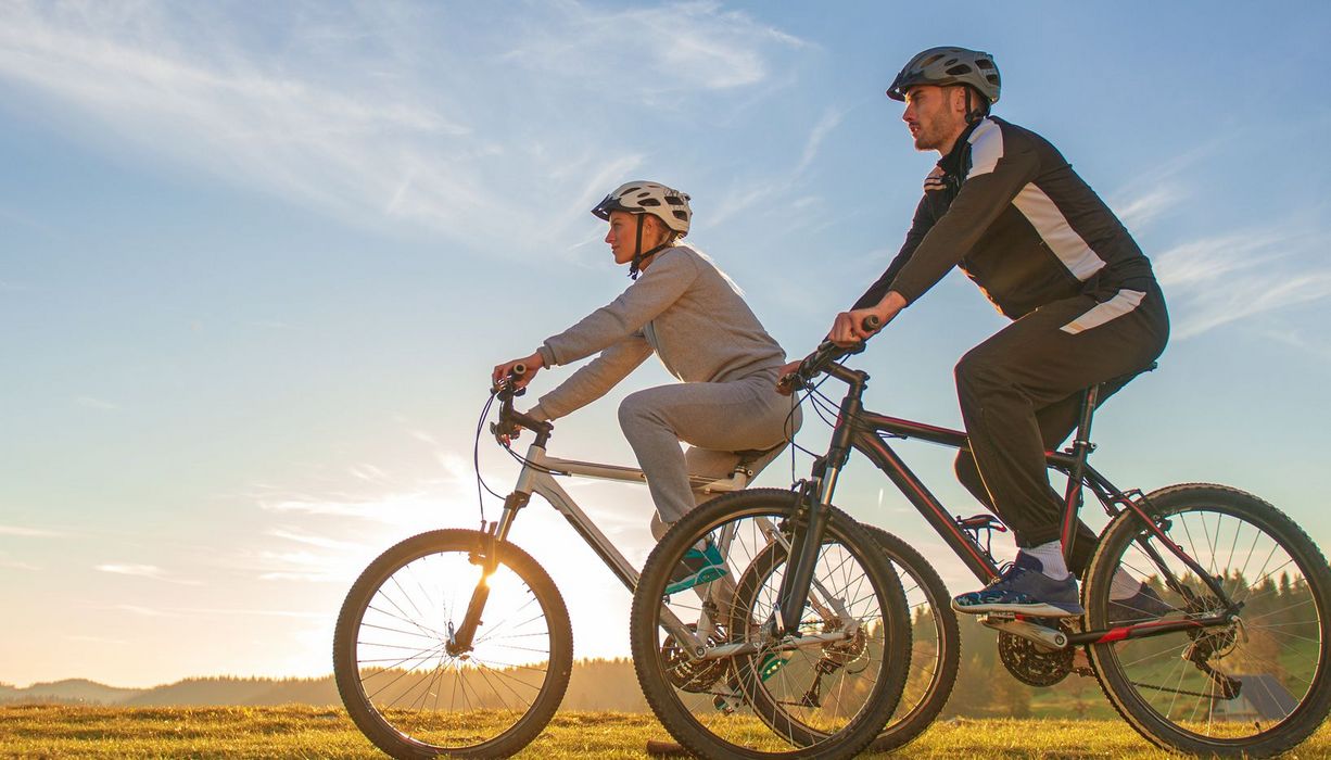 Ein Paar fährt auf Mountainbikes im Sommer.