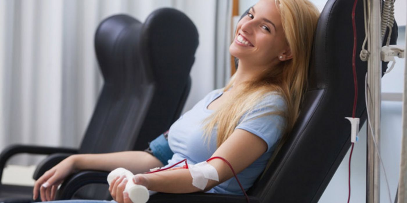 Junge Frau auf einer Liege beim Blutspenden.