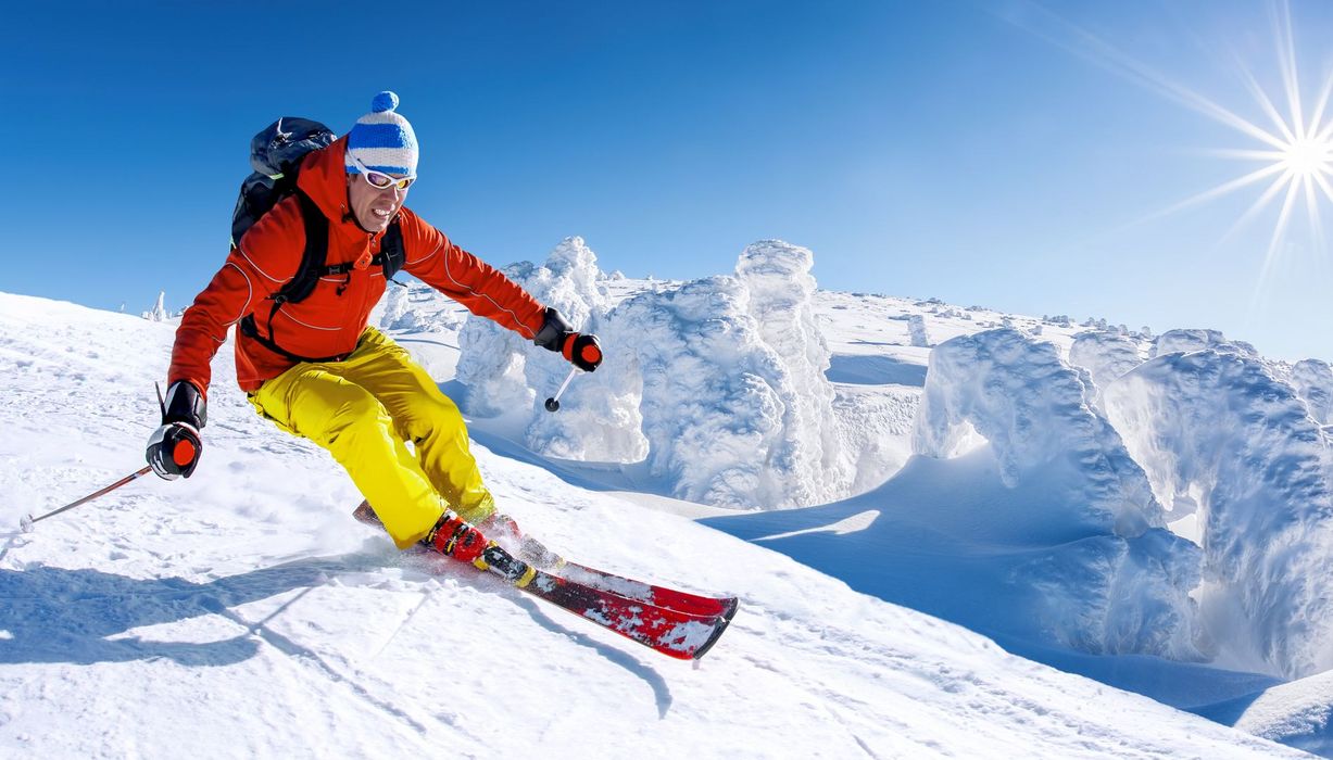 Skifahrer in einer Kurve bei strahlendem Sonnenschein.