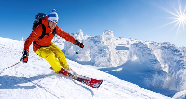 Skifahrer in einer Kurve bei strahlendem Sonnenschein.