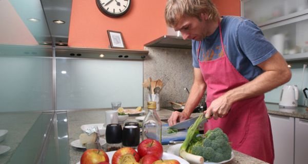 Mann in der Küche beim Schneiden von Gemüse