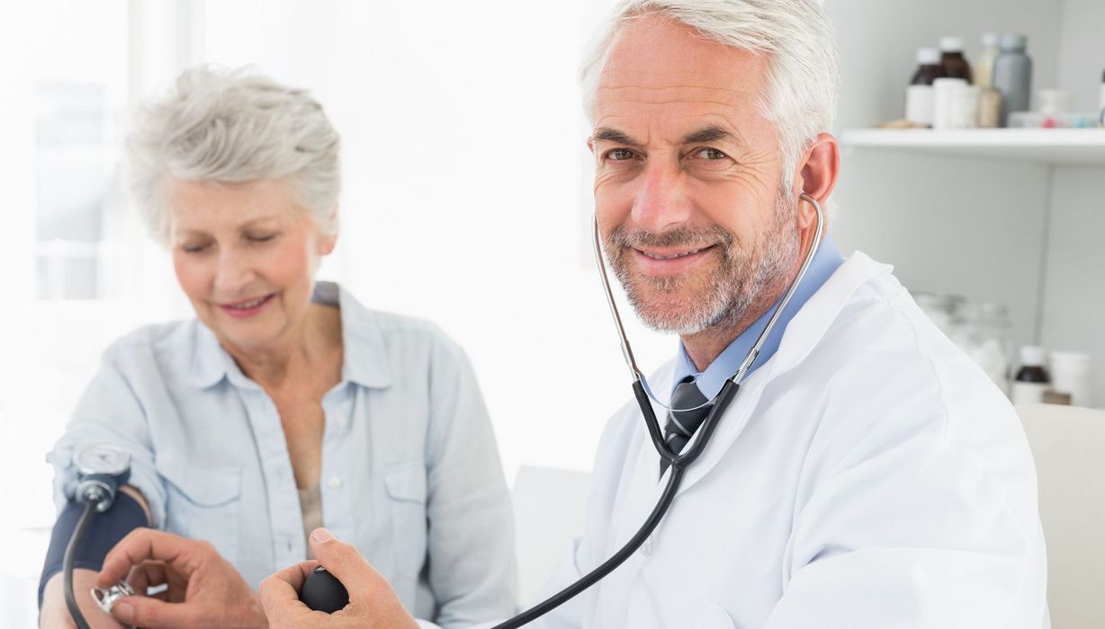 Arzt misst einer älteren Frau den Blutdruck