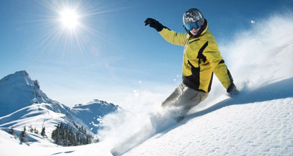 Skifahrer düst bei strahlendem Wetter die Piste hinab