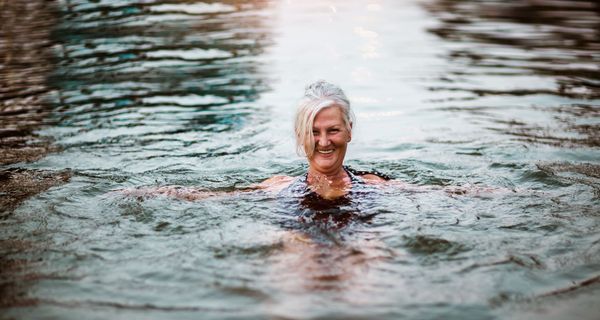 Ältere Frau, schwimmt in kaltem Wasser.