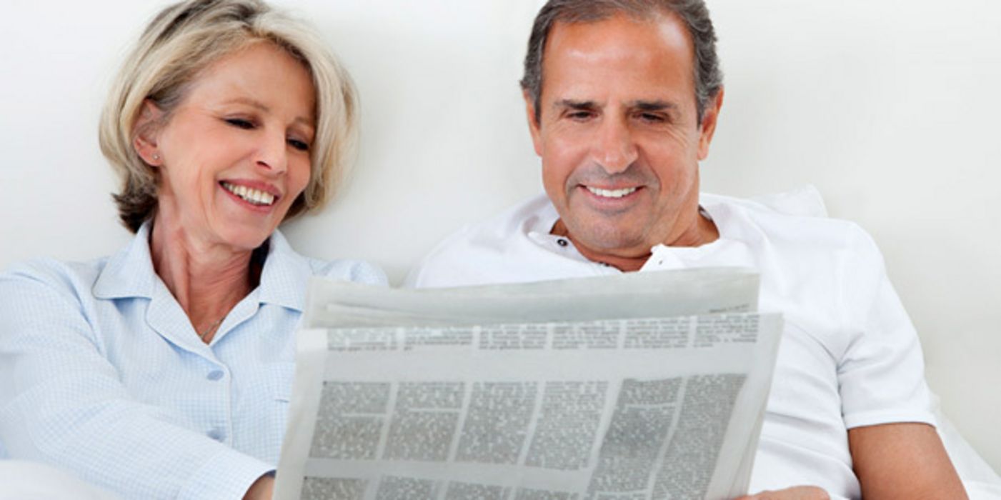 Frau und Mann lesen Zeitung.