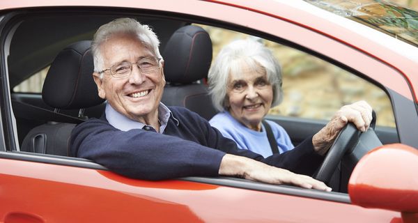 Älteres Paar sitzt im Auto.