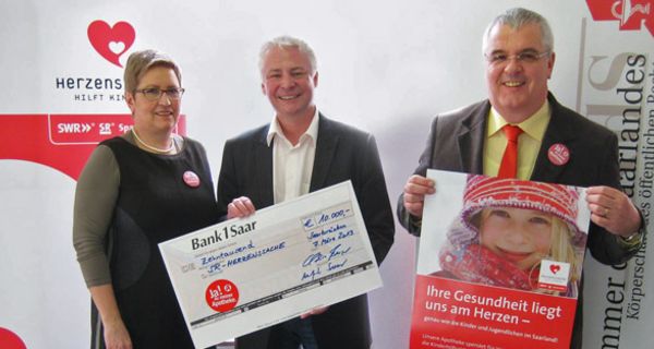 Claudia Berger, Vorsitzende des Saarländischen Apothekervereins e. V., Thomas Rosch, Saarländischer Rundfunk, und Manfred Saar, Präsident der Apothekerkammer des Saarlandes, bei der Übergabe des Spenden-Schecks.