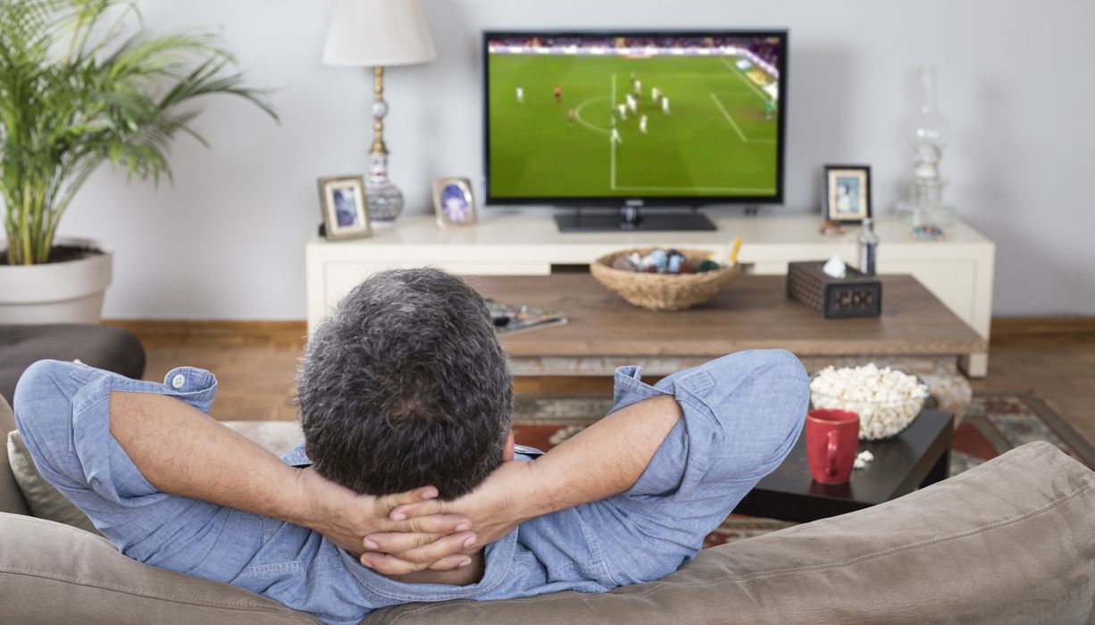Mann schaut Fußball im Fernsehen.