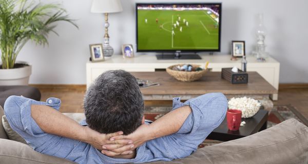 Mann schaut Fußball im Fernsehen.