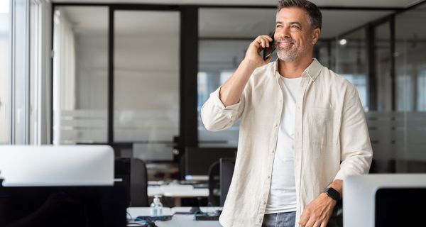 Mann, telefoniert bei der Arbeit im Stehen.