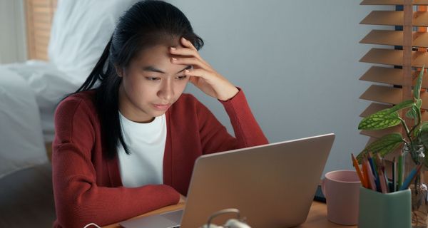 Jugendliches Mädchen, sitzt vor ihrem Laptop.