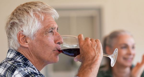 Senior trinkt ein Glas Wein 