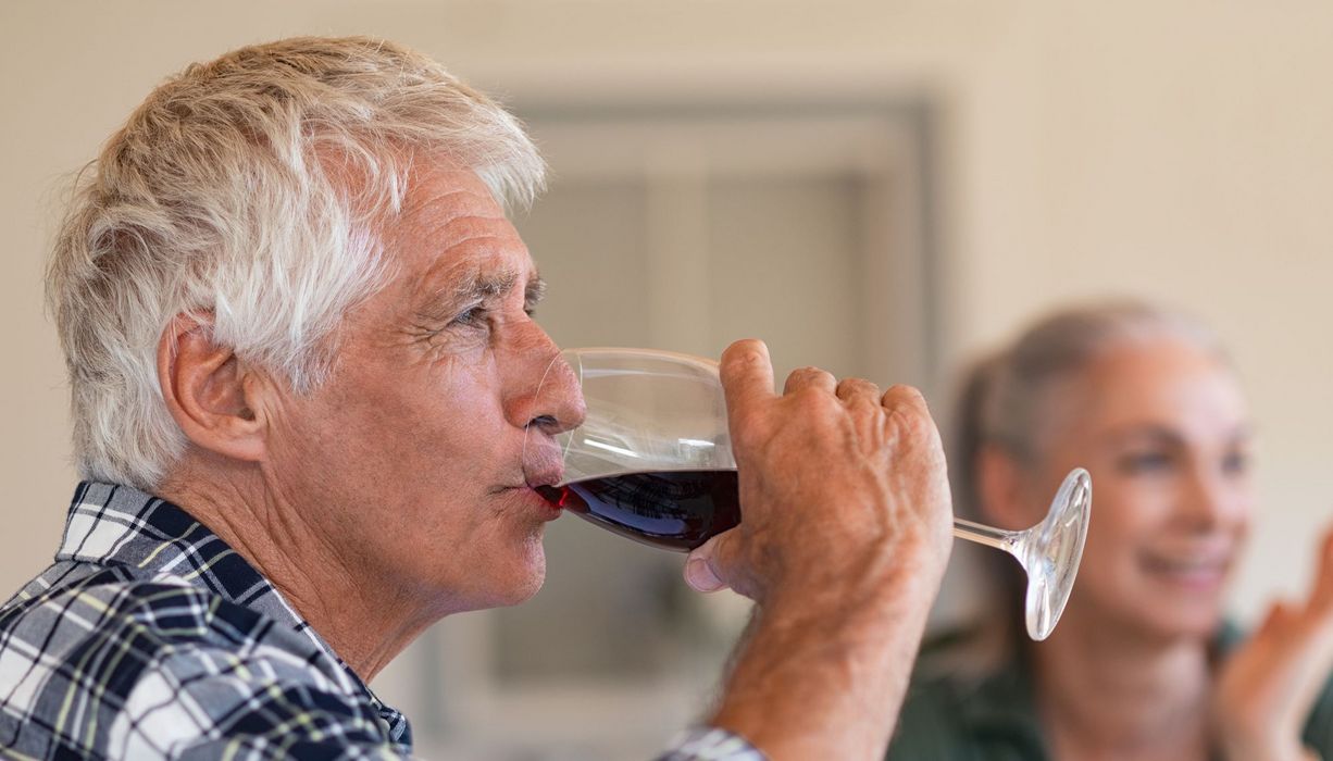 Senior trinkt ein Glas Wein 