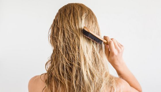 Frau bürstet ihre langen Haare