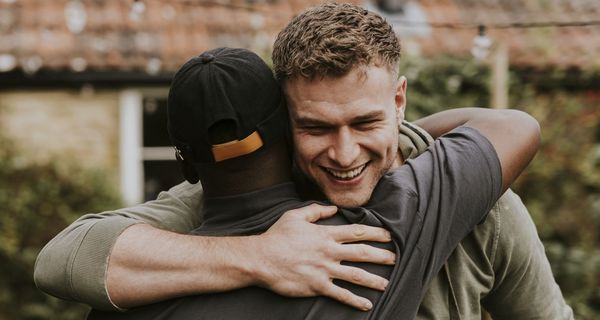 Zwei Männer umarmen sich.