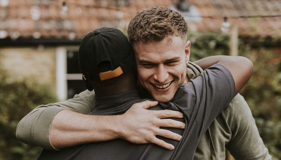 Zwei Männer umarmen sich.