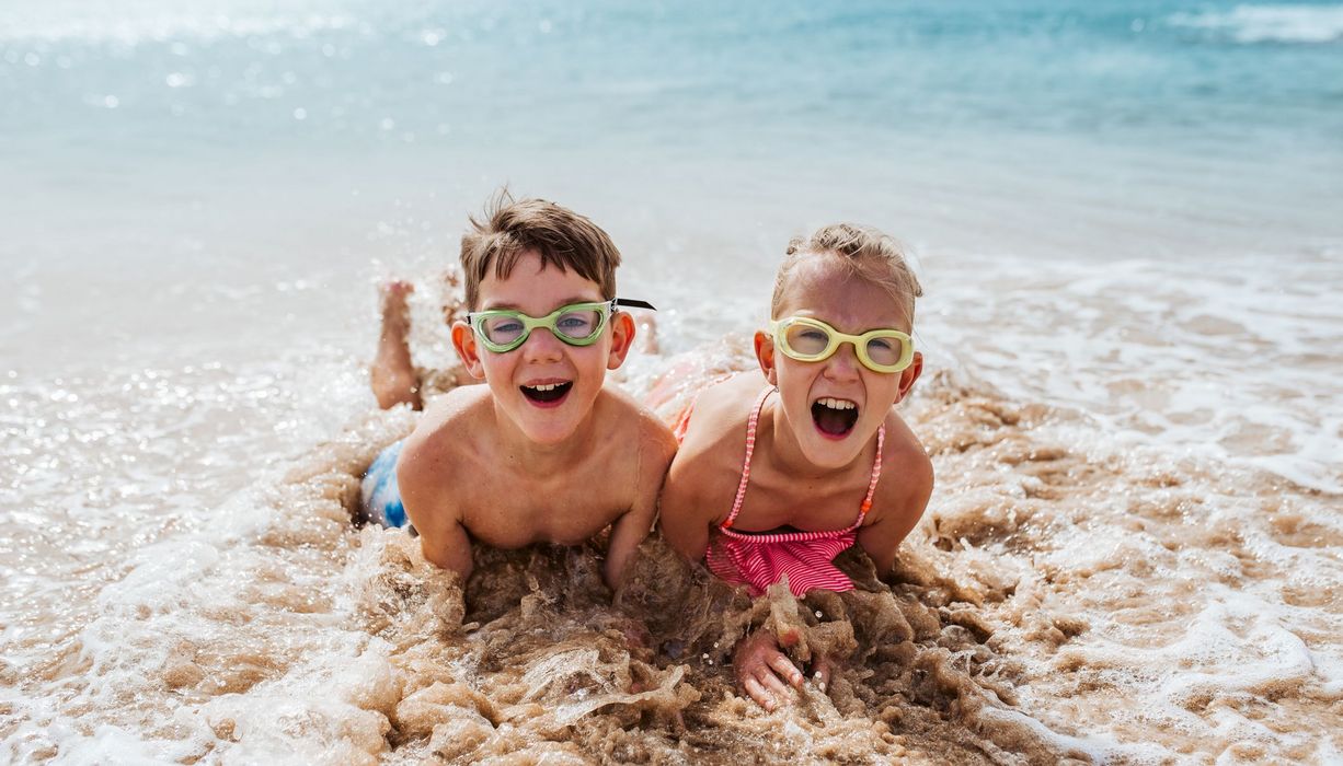 Zwei Kinder, zusammen am Meer.
