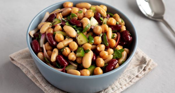 Schüssel mit Drei-Bohnen-Salat, daneben ein Löffel.