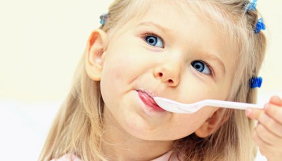 Kindergartenkind isst Joghurt.