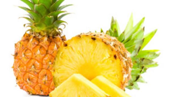 Eine aufgeschnittene Ananas und eine ganz dahinter.