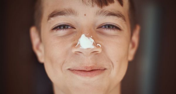 Jugendlicher mit einem Klecks Sonnencreme auf der Nase.