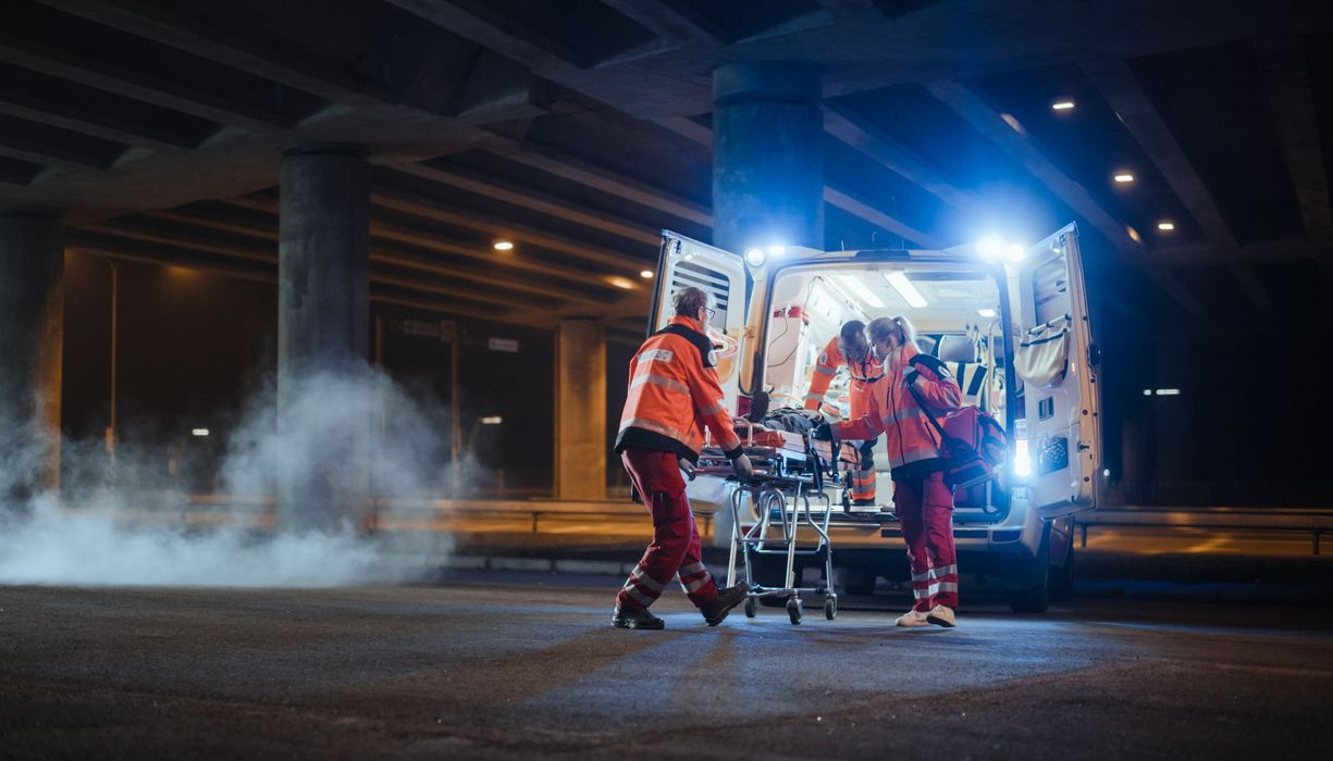 Patient, wird von einem Rettungsfahrzeug abgeholt.