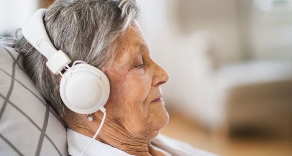 Ältere Frau mit Kopfhörern.