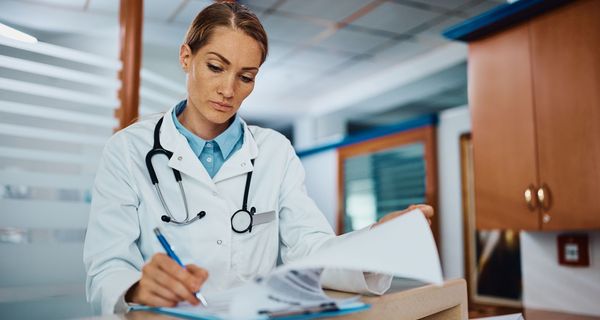 Eine Ärztin füllt eine Krankenakte im Krankenhaus aus.