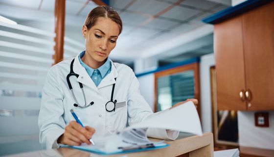 Eine Ärztin füllt eine Krankenakte im Krankenhaus aus. 