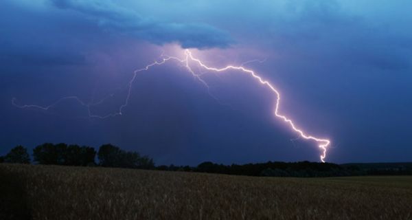 Gewitterlandschaft mit Getreidefeld im Vordergrund