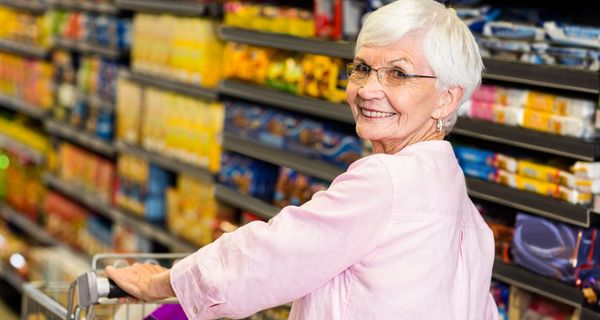 Seniorin, kauft im Supermarkt ein.