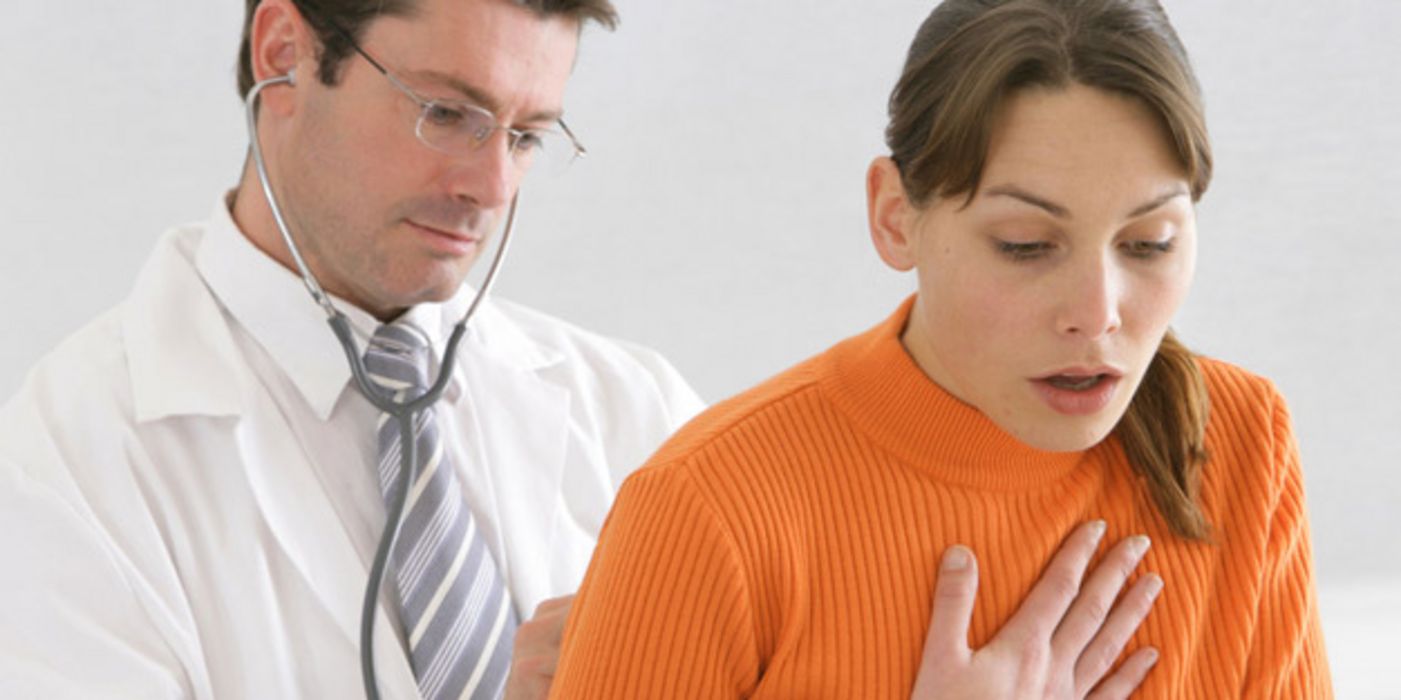 Arzt hört hustende Patientin ab