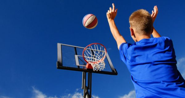 Junge wirft Basketball.