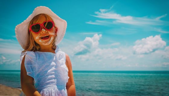 Mädchen mit Sonnenhut und Sonnenbrille.