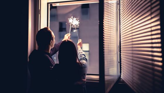 Pärchen, hält Wunderkerzen aus dem Fenster.