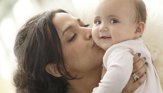 Junge Mutter hält ihr Baby.
