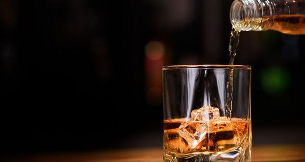 Whiskey, wird von einer Flasche in ein Glas gegossen.