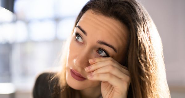 Junge Frau, reibt sich ihr Auge.