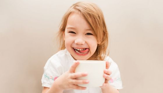 Fröhliches Mädchen mit Teetasse