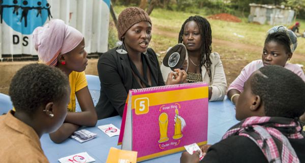 Afrikanische Jugendliche sitzen um einen Tisch.