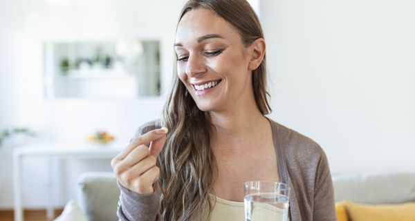 Junge Frau, nimmt eine Vitamintablette.