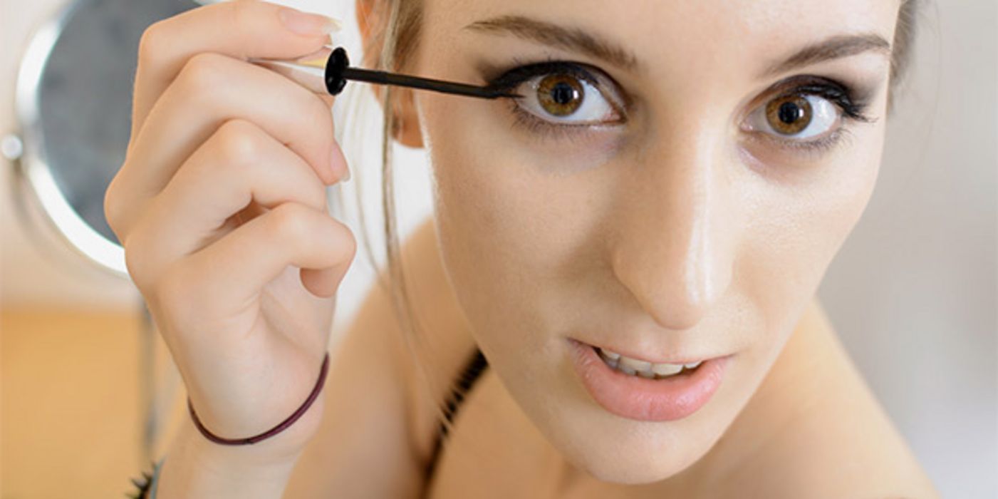 Nahaufnahme Gesicht junge Frau beim Auftragen von Eyeliner