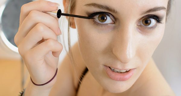 Nahaufnahme Gesicht junge Frau beim Auftragen von Eyeliner