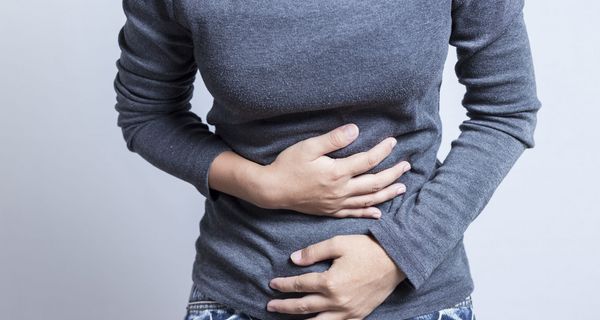 Frau, legt ihre Hände auf ihren Bauch.