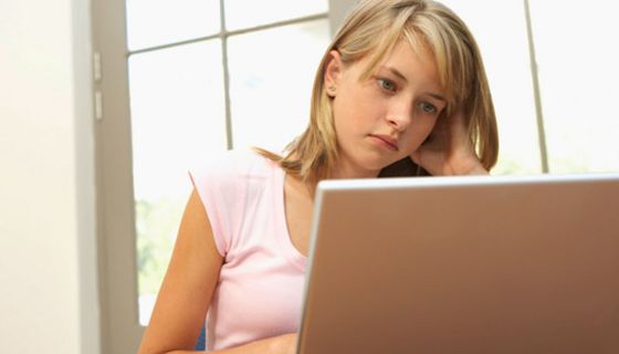 Jugendliche vor einem Laptop mit kritischem Blick