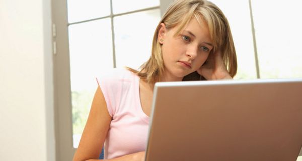 Jugendliche vor einem Laptop mit kritischem Blick