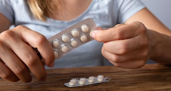 Frau mit zwei Tabletten-Packungen.