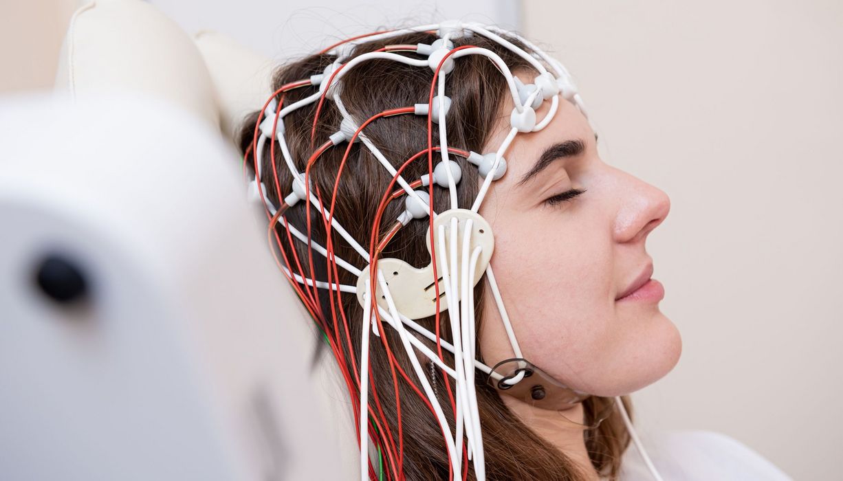 Frau mit Elektroden am Kopf.