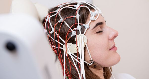 Frau mit Elektroden am Kopf.