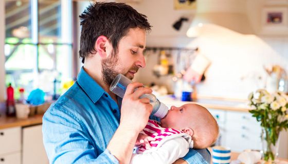 Vater gibt seinem Baby ein Fläschchen.